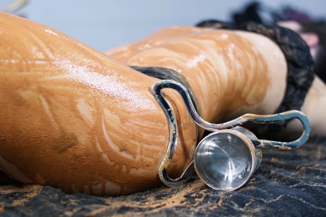 Ice and clay detox body sculpting treatment with a metal sculpting tool